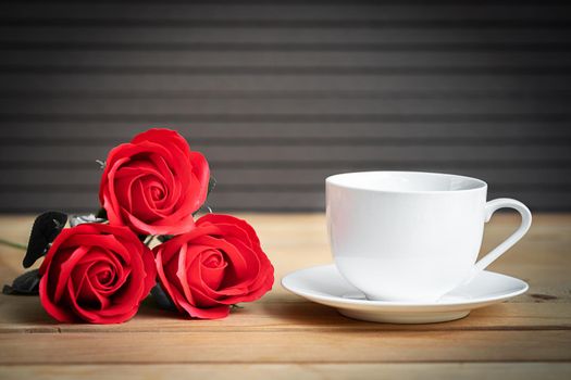 Red rose and coffee cup on wood background, Valentine concept