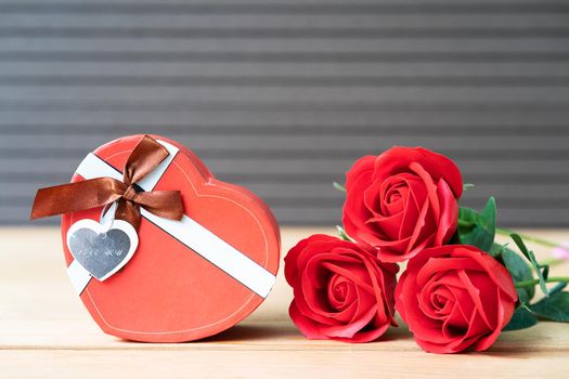 Close up red roses and heart-shaped box on wood background,Valentines Day concept with roses and red heart-shaped box