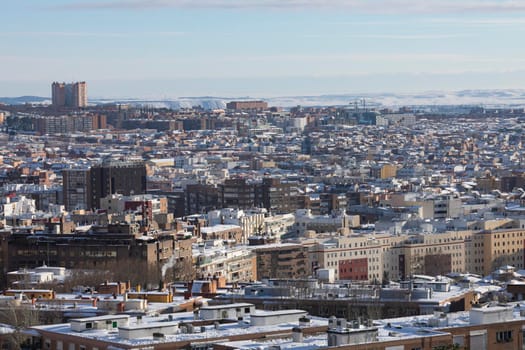 Madrid, Spain - January 10, 2021: Aerial view of Madrid, towards the Vallecas area, covered with snow, on a snowy day, due to the Filomena polar cold front.