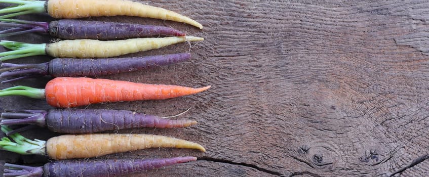 rustic kitchen with raw vegetables on old wood. Top view. Fresh carrots