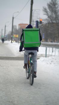 Courier is delivering food with backpack at winter.