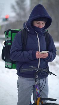 delivery man with green bagpack awaiting the order for delivery.