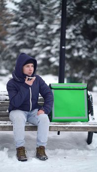 food delivery courier waiting for a customer's address and records a voice message on the phone.