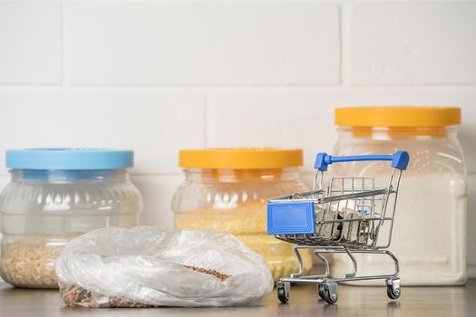 Kazakhstani tenge KZT in a grocery basket with bread, buckwheat grain and cereals. Rising prices for food and groceries in Kazakhstan and other countries. Humanitarian aid.