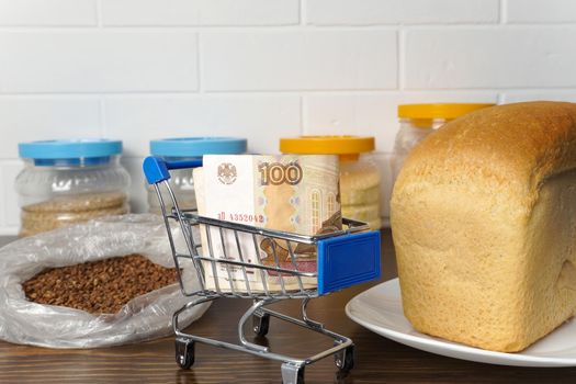 Russian ruble in a grocery basket with bread, buckwheat grain and cereals. Rising prices for food and groceries in Russia and other countries. Humanitarian aid.                            