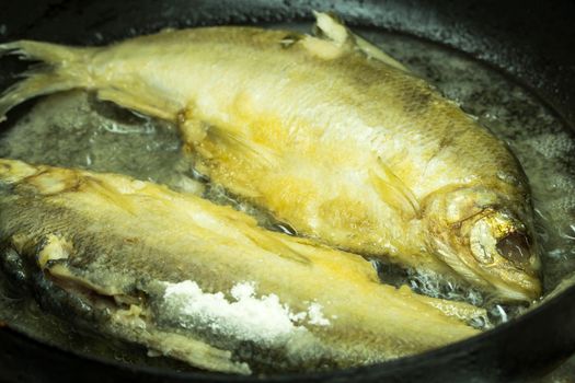 fish in batter with a crispy crust is fried in breadcrumbs flour and cooked in a pan with oil. Recipe for traditional fried fish cooking