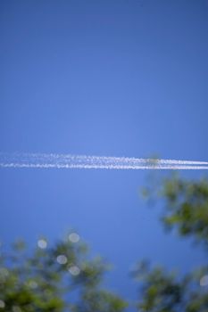 Two contrails left in the deep blue sky by an airplane
