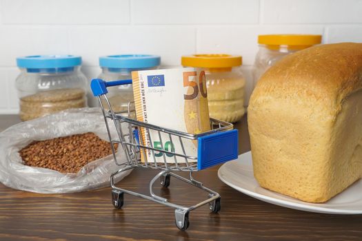 50 Euros in a grocery basket with buckwheat, bread and cereals. Rising food prices and groceries in Europe and other countries. Humanitarian assistance  