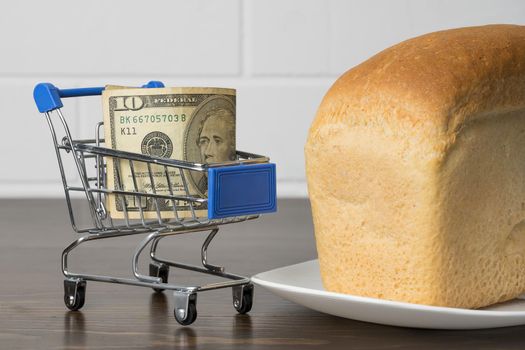 10 Dollars in a grocery basket with bread. Rising food prices and groceries in USA America and other countries. Humanitarian assistance