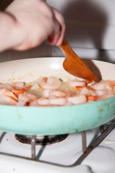 A pound of raw, thawed shrimp in a frying pan