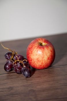 Washington apple and red seedless grapes on a wooden table