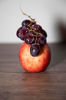 Washington apple and red seedless grapes on a wooden table