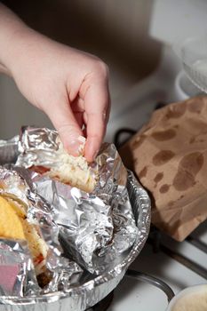 Woman dropping shredded white cheese on a pair of tacos