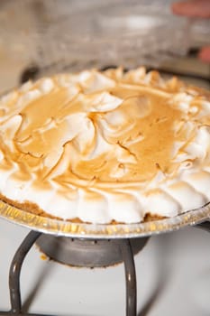 Close up of a whole lemon meringue pie on a stove