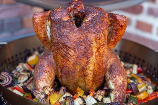 Rubbed Beer can chicken on barbecue with smoked veggies