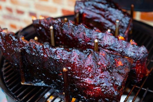 Cherry glazed spare ribs in a rack on the barbecue