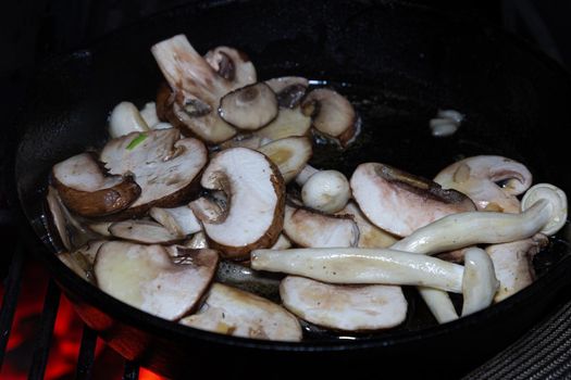 Mushrooms in a skillet on a barbecue fire