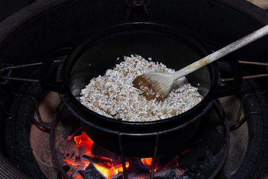 Making truffle risotto on barbecue in dutch oven