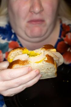 Woman eating a chicken and cheese sandwich that doesn't taste well