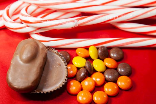 Christmas chocolates and candy canes on a red tabletop