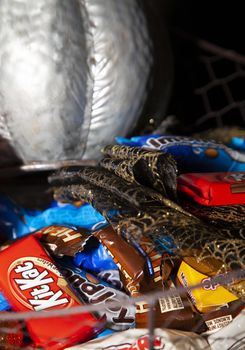 LOUISIANA/USA – OCTOBER 31 2019: Silver pumpkin, orange pumpkin, small sequined pumpkins, black and gold mesh decoration, with Reese's, Heath Bars, Milk Duds, Kit Kat, Whoppers, Almond Joy, and Baby Ruth candies to hand out.