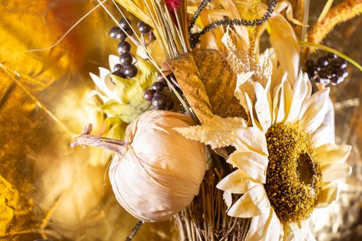 Purplish black berries and a pale sunflower with a golden background