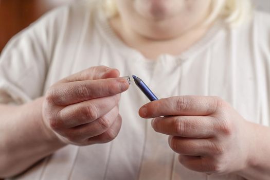 Woman removing the cap from blue eyeliner that she is ready to use