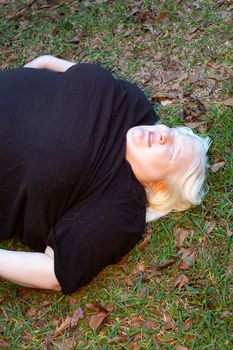 Obese woman lying unconscious on the ground outdoors