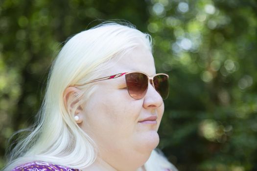 Close up of an albino woman wearing shades in nature
