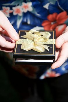 Woman opening a black gift box with a gift card in it