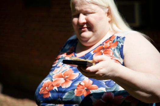 Albino woman holding a black gift box with a golden ribbon