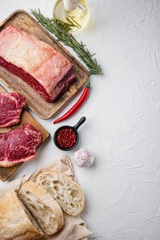 Raw beef steak burger ingredients, with marbled meat, on white background, top view, with copy space for text
