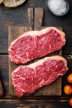 New York steak raw beef meat, on dark wooden background, top view