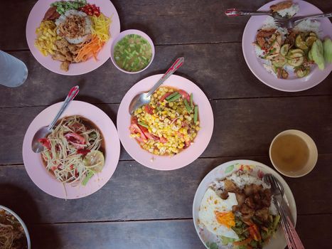 Top view Thai food on table: Eating north eastern foods (SOM TUM - Spicy Papaya Salad, Sticky rice). Local and traditional way. Thai Food Background. enjoy eating concept