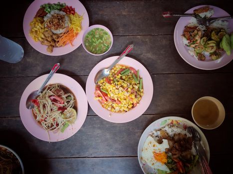 Top view Thai food on table: Eating north eastern foods (SOM TUM - Spicy Papaya Salad, Sticky rice). Local and traditional way. Thai Food Background. enjoy eating concept