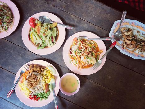 Top view Thai food on table: Eating north eastern foods (SOM TUM - Spicy Papaya Salad, Sticky rice). Local and traditional way. Thai Food Background. enjoy eating concept