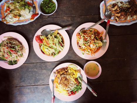 Top view Thai food on table: Eating north eastern foods (SOM TUM - Spicy Papaya Salad, Sticky rice). Local and traditional way. Thai Food Background. enjoy eating concept