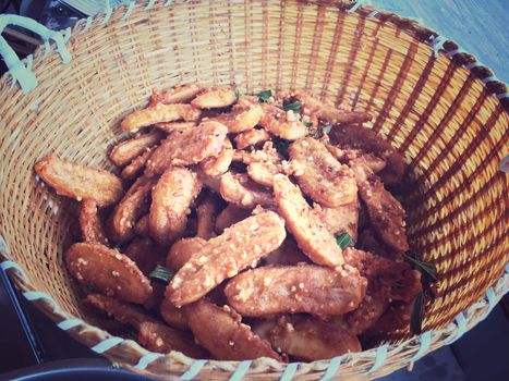 tasty deep fried bananas with sesame in wooden baket in the market,thai food