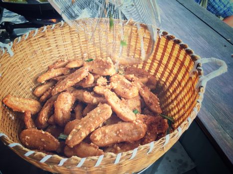 tasty deep fried bananas with sesame in wooden baket in the market,thai food