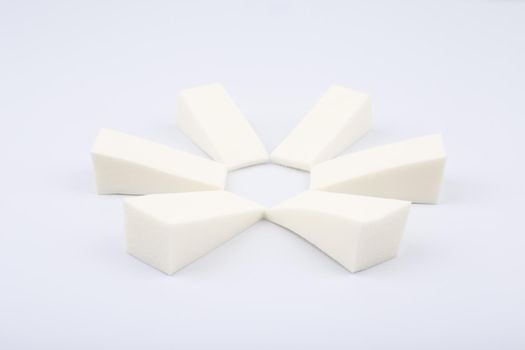 Triangle shaped make up sponges arranged in a circle on white background. High quality photo
