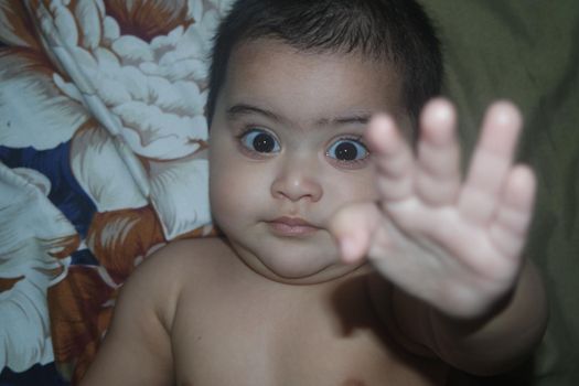 Baby girl with lovely face, big eyes and cute face gesture. Baby girl playing with camera