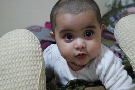 Baby girl with lovely face, big eyes and cute face gesture. Baby with bald head staring at camera.