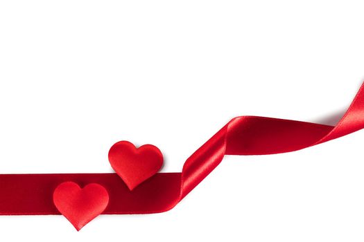 Valentine's day two red silk hearts and curled red satin ribbon isolated on white background, love concept