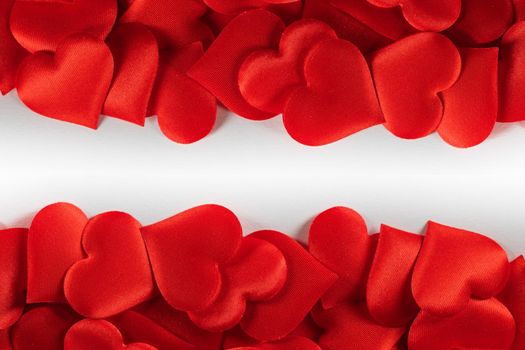Valentine's day many red silk hearts background , border frame on white with copy space, love concept