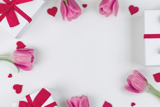 Pink tulip flowers gifts and red hearts composition on white background top view with copy space. Valentine's day, birthday, wedding, Mother's day concept. Copy space