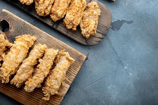 Crispy kentucky fried chicken cuts on grey background, top view, with space for text.