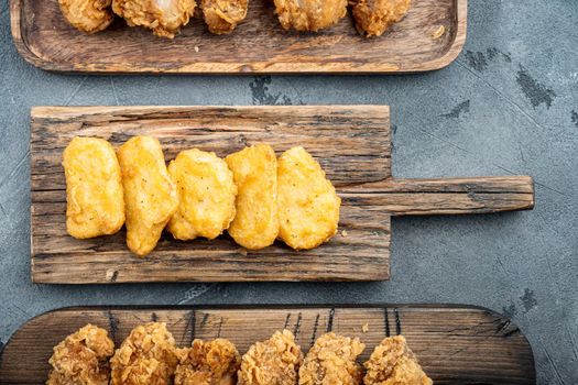 Fried crispy chicken nuggets meat on grey background, top view.