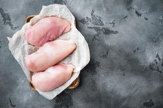 Chicken uncooked meat on grey background, flat lay with copy space