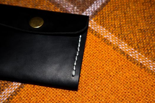 Leather wallet stitched with white threads on