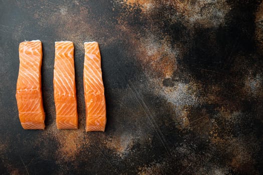 Raw salmon fillet, on old rustic background, flat lay with space for text